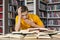 Yawning student sitting in front of books in library