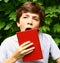 Yawning teen boy with book