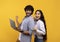 Yeah. Excited indian couple holding laptop, cheering and looking at camera, celebrating victory, yellow background