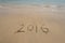 Year 2016 written in sand on beach