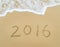 Year 2016 written in sand on beach