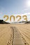 Year 2023 dawning on a light sandy beach. New year concept