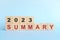 Year 2023 review and summary concept. Wooden blocks in blue background.