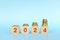 Year 2024 financial success, save, invest and grow money. Increasing stack of coins in wooden blocks.