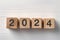 The year 2024 text on wooden cube. A new era of creative inspiration and concept background. Make a fresh start in your planning