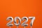 Year 2027 - Silver number on orange foamy background