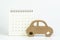 Yearly car maintenance schedule, car loan payment, mortgage and leasing concept, miniature wooden car on clean calendar with date
