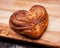 Yeast sweet buns in the shape of a heart on a Board on black baking tray. Country house style. Authentically