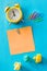 A yellow alarm clock, along with colorful, blank note cards. Top view. Colorful office staples, washed-out paper balls, pens, Spa