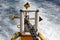 yellow anchor with metal chain of a sea ship. Close-up of white waves behind the tail of a motor boat