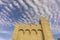 The yellow antique brick building of church under wave of softy and white fluffy clouds  deep blue sky background