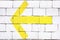 A yellow arrow on a brick wall