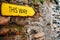 Yellow arrow sign on old stone brick wall. Direction pointer with inscription This Way