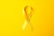 Yellow awareness ribbon on color background