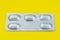 Yellow background.Blister or pack of five tablets or pills. The concept of five working days. Yellow background