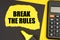 On a yellow background, a calculator, a black sheet, a marker and a yellow torn sheet with the inscription - BREAK THE RULES