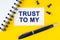 On a yellow background lies a notebook, a pen and a business card with the inscription - Trust to My