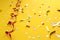 On a yellow background lies a swirling ribbon and festive confetti