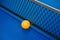 Yellow ball hits the bottom of racket on blue pingpong table