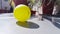 A yellow ball with its shadow falling on the ground