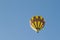 Yellow balloon against a blue sky. Aerostat. People in the basket. Fun. Summer entertainment. Romantic adventures