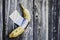 Yellow banana duct-taped to a weathered wooden wall - Concept of potassium and healthy lifestyle with seasonal fruit - Vitamins