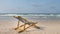 An yellow beach chair rests on the white sand of the beach and B