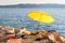 Yellow beach umbrella on summer ocean coast. Sea beach with sun umbrella is waiting for tourists on Sunset. Happy summer vacations