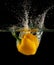 Yellow bell pepper dropped and slashing on water