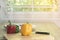 Yellow bell peppers are placed on a wooden cutting board with knives  plates  all on the wooden table. real image.