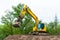 Yellow belt excavator on construction site. Hydraulic earth mover