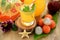 Yellow beverage in glass vessels surrounded by tropical fruits