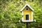 Yellow birdhouse in a garden