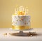 a yellow birthday cake with gold stars on top