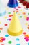 Yellow birthday party cap and confetti