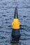 Yellow an black buoy on the waves of the river in the windy day