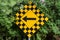 yellow and black checkerboard diamond road caution sign with black arrow pointing left