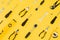 Yellow and black handy tools & x28;pilers and screwdriver& x29; isolated on yellow background.