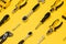 Yellow and black handy tools (pilers and screwdriver) isolated on yellow background.