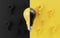 Yellow and black lightbulb among question mark and black background for creative thinking idea and solution problem solving