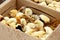 Yellow and black little broiler chickens with down on the body sit in a cardboard box close-up top view. newborn chicks