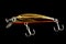 Yellow and black minnow plastic fishing lure isolated on black