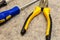 Yellow black pliers close-up screwdriver background base design repair fasteners