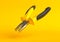Yellow-black pliers isolated on yellow background