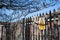 Yellow and black Warning Razor Wire sign on a metal bourndary fence with razor wire visible on top