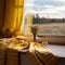 A yellow blanket sitting on top of a window sill next to a window sill with a view of a field