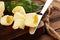 Yellow block of fresh butter sliced on wooden cutting board and butter swirls. Slices of margarine or spread, fatty natural dairy