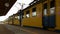 Yellow and blue city suburban train leaving station, destination, transportation
