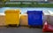 Yellow and blue garbage bin stand on the embankment in the city.