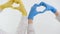 yellow blue gloves cardiology treatment of heart diseases help hospital hands of two doctors show heart with their hands